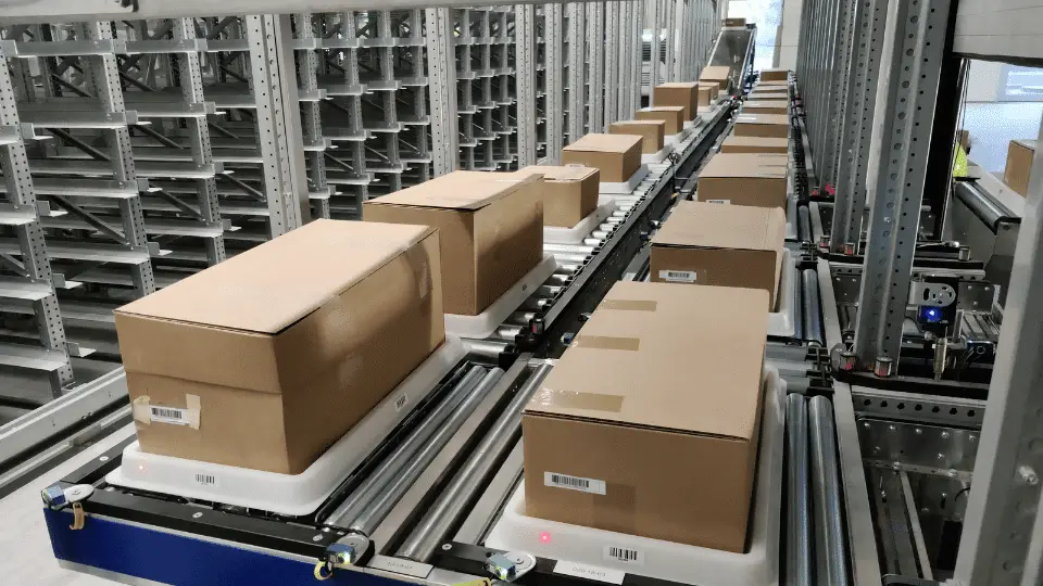 Cardboard boxes on an automated conveyor system in a warehouse.