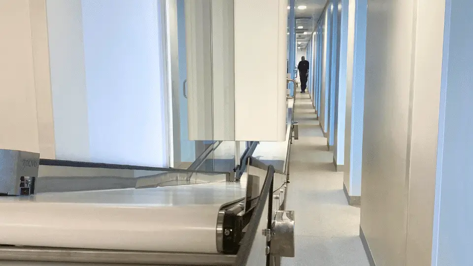 A clean industrial corridor with a conveyor belt system.